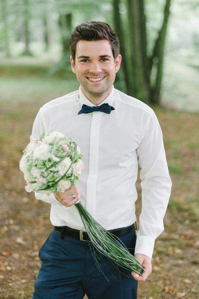Traditionelle Hochzeit Bräutigam mit Brautstrauß aus weißen Dahlien mit Hortensien und rosa Rosen